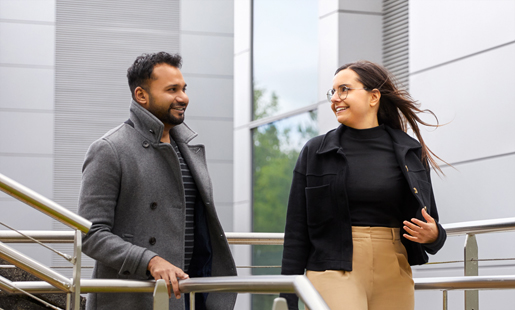 Federica caminando en unas escaleras con un compañero de trabajo.
