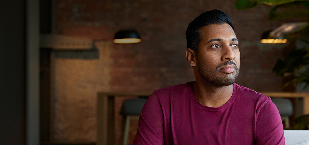 Amar sentado en un lugar cerrado, mirando a su izquierda.