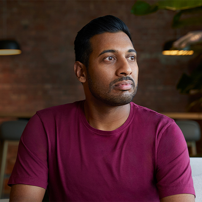 Amar sentado en un lugar cerrado, mirando a su izquierda.