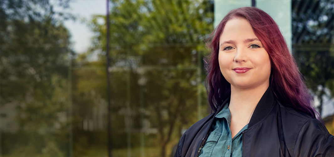 Alexa parada en el campus mirando a la cámara.