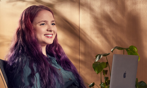 Alexa sentada trabajando en su laptop.