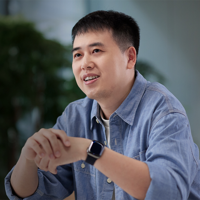  Ken sentado en un espacio en interiores lleno de plantas.