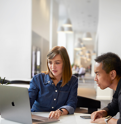 Una empleada de Soporte y Servicio técnico de Apple Cork hablando con una compañera de trabajo.