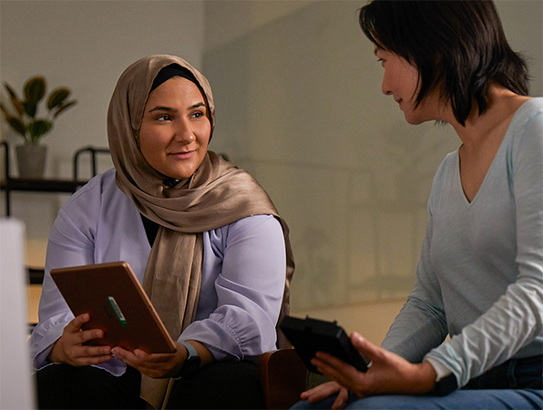 Dos personas del equipo de Machine Learning e Inteligencia artificial de Apple colaborando juntas, una con un iPad y otra con un iPhone.