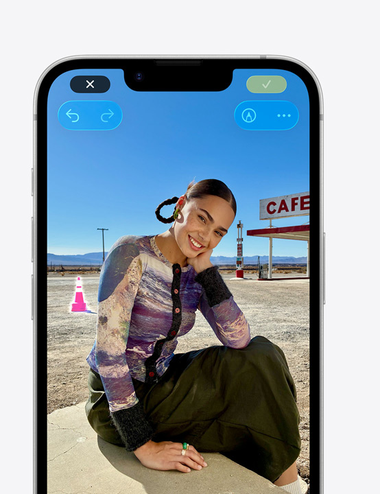 iPhone Display, Foto einer lächelnden Person am Strand, mit dem Bereinigen Tool wird ein Pylon im Hintergrund entfernt