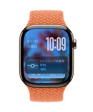 タンジェリンのブレイデッドバンドを組み合わせたゴールドチタニウムのApple Watch。画面の左上に日付、右上に時刻を示す数字、下部にトレーニングの負荷のウィジェットがあり、すべて半透明のLiquid Glassで表示されている