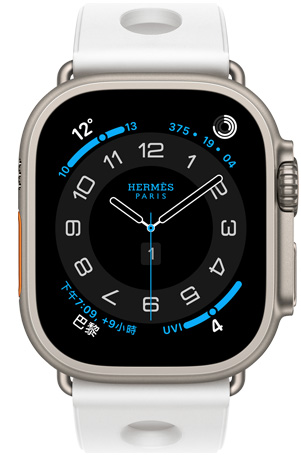 Apple Watch Hermès Ultra 3，展示原色鈦金屬錶殼、Hermès Circulaire 錶面與多項複雜功能，包括天氣、活動記錄圓圈、巴黎時間與紫外線指數，搭配 Blanc 白色 Scub'H Diving 錶帶