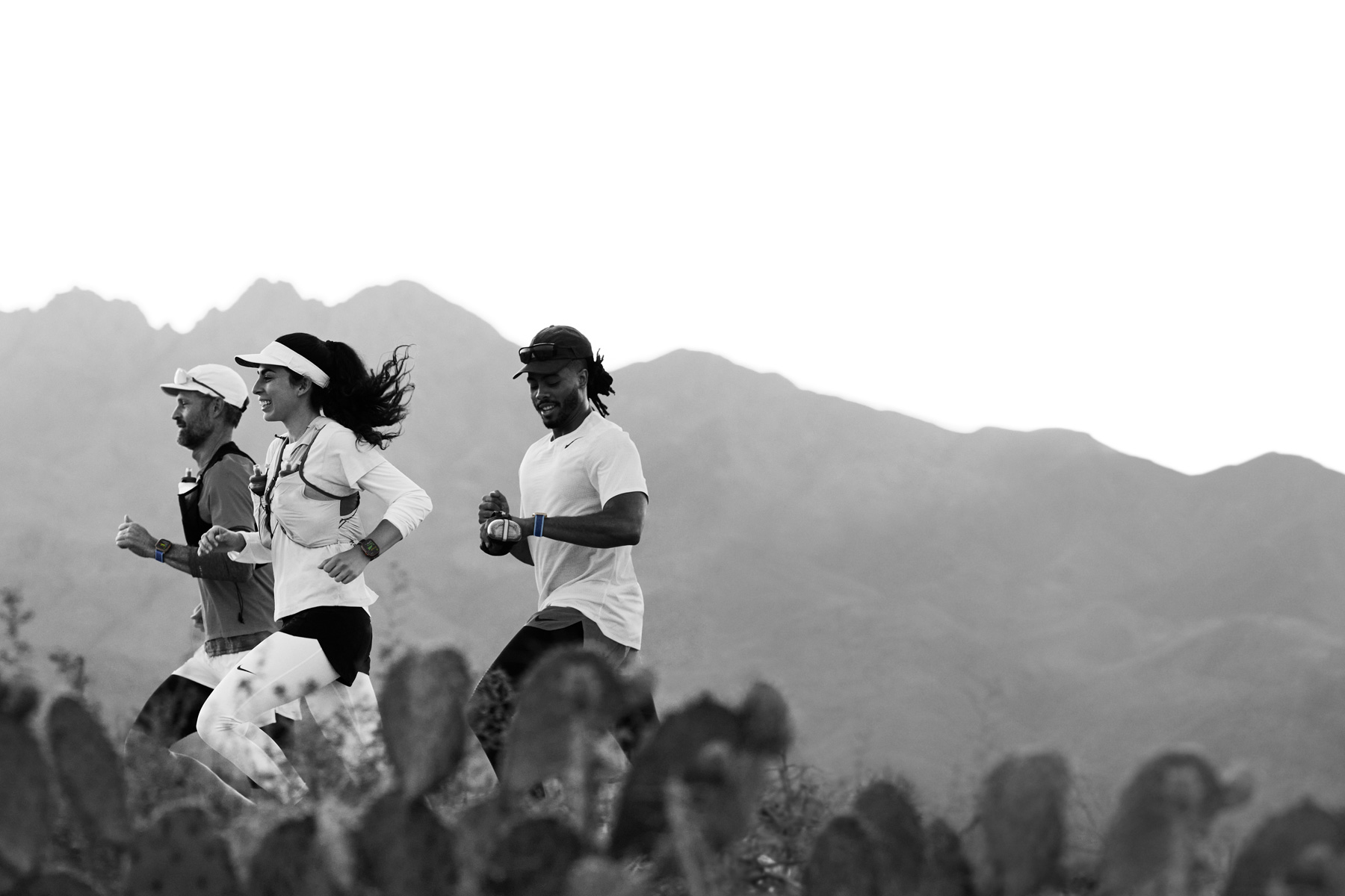 Løbere på en sti i ørkenen registrerer deres træning på Apple Watch Ultra 3