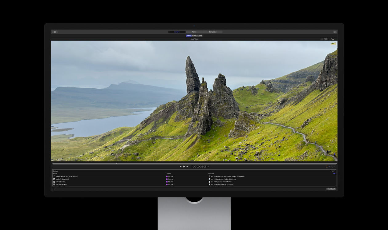 Mac Studio Display screen showing Compressor, rocky crags in a barren seaside landscape with green grass, demo of batch export