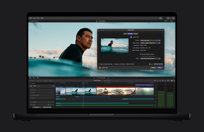 MacBook Pro 16 screen showing an image of a surfer in the ocean waiting for a wave, export file window open, video clip timeline at the bottom of the screen