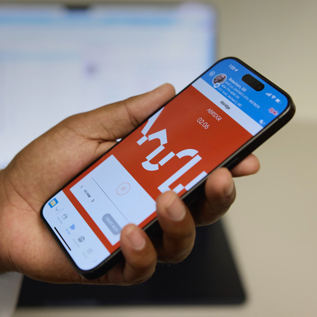Eine Hand hält ein iPhone, das die Abridge App anzeigt, die Gespräche zwischen Patient:innen und Ärzt:innen in klinische Notizen übersetzt.