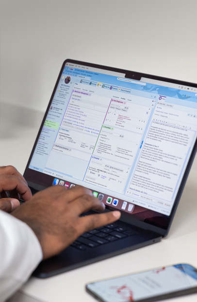 Ein Arzt, der elektronische Patientenakten auf einem MacBook Pro prüft.