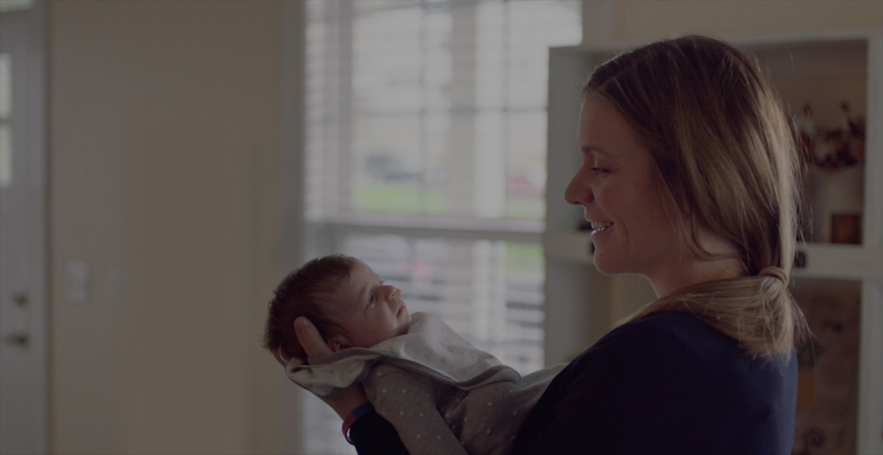En nybagt mor smiler til sin baby.