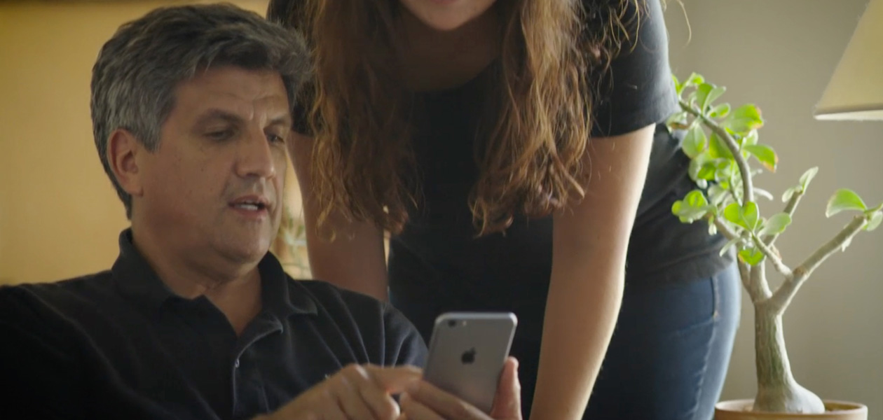 Ein Mann teilt seine Gesundheitsinformationen auf einem iPhone mit der Frau neben ihm.