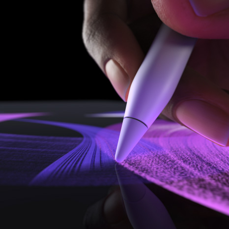 قلم Apple&nbsp;Pro، الجزء الجانبي الخارجي، لون أبيض، يد تحمل القلم وترسم خط فرشاة أزرق زاهياً