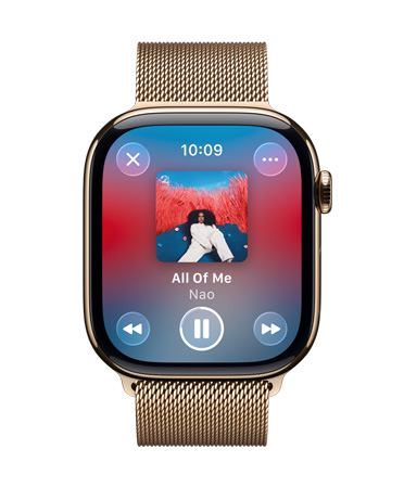 Apple Watch i guldfarvet titanium med Milanorem. Urskiven viser, at Apple Music afspilles, gennemsigtige Liquid Glass-betjeningsfunktioner.