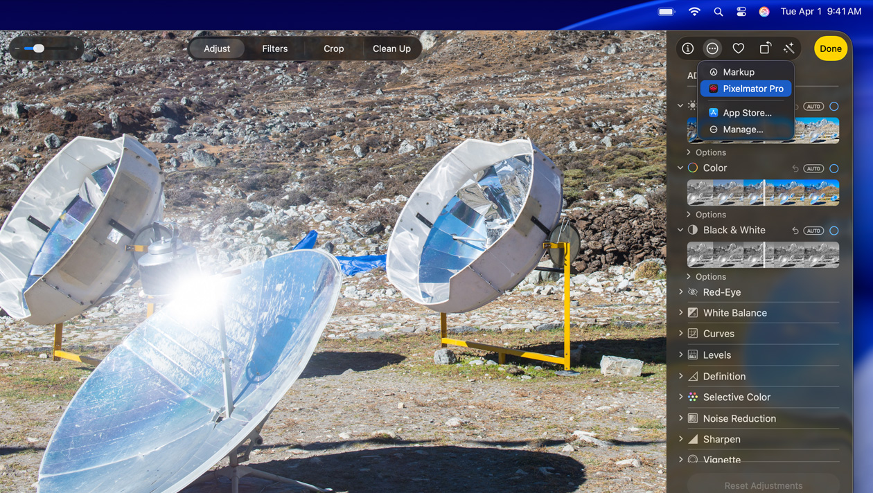 A tela do MacBook Pro de 16 polegadas mostra a foto de três telescópios prateados no chão com as ferramentas de edição de imagem