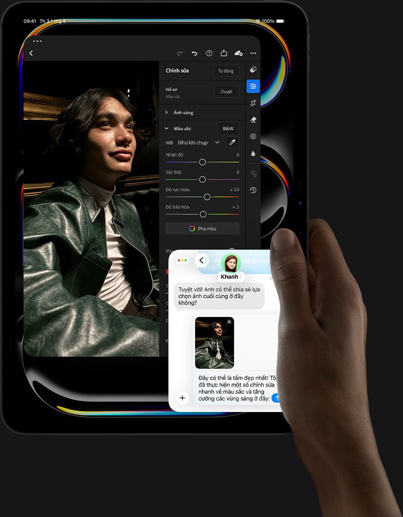 iPad Pro, front exterior, portrait orientation, space black color, right hand holding device, display showing photo editing app with image of a person in a leather jacket, editing tools and sliders,  iMessage conversation happening between user and another individual reviewing the photo